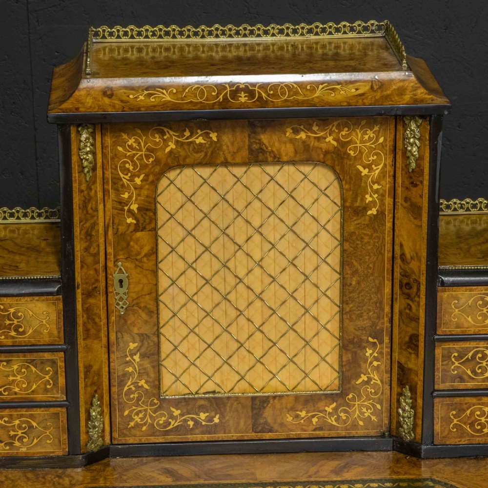 A Victorian burr walnut bonheur de jour featuring floral marquetry inlays, gilt brass mounts, cabriole legs, and a green leather writing surface. View XII