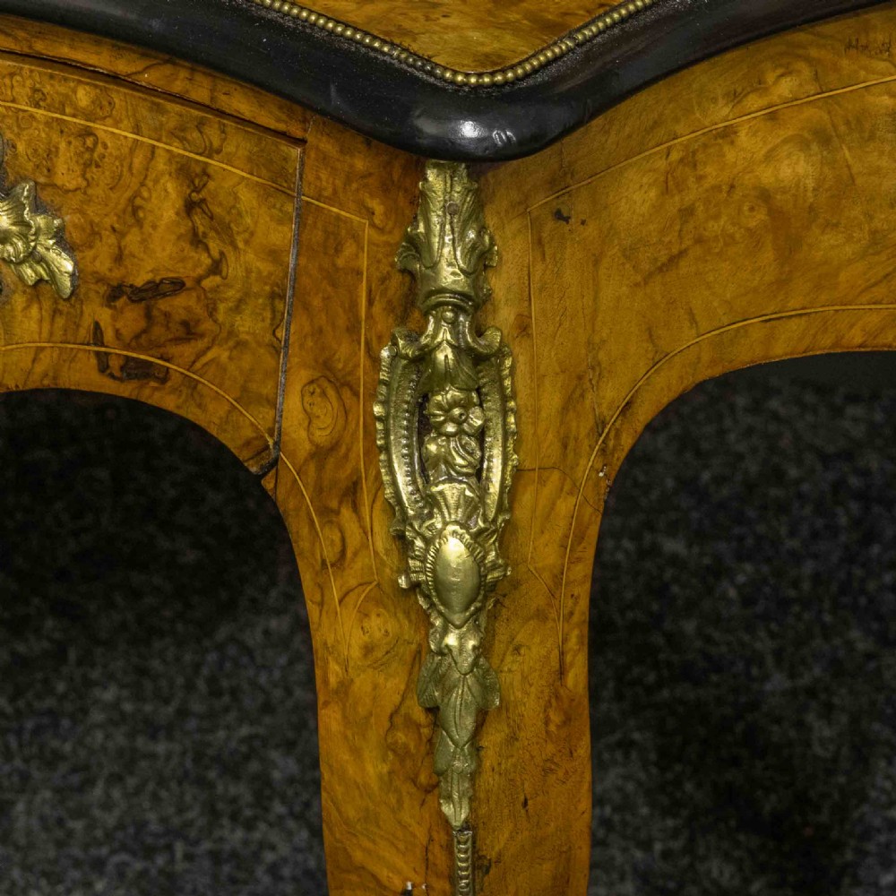 A Victorian burr walnut bonheur de jour featuring floral marquetry inlays, gilt brass mounts, cabriole legs, and a green leather writing surface. View XVII