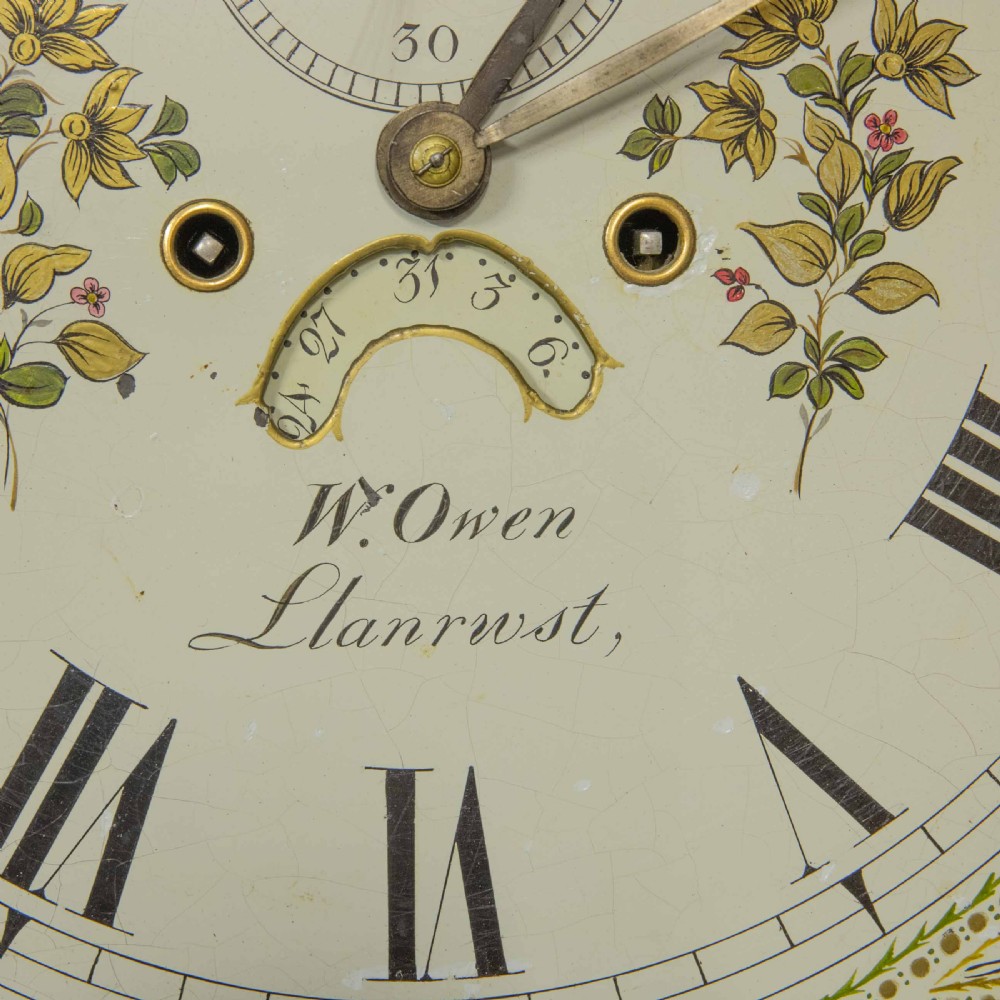 A Georgian mahogany longcase clock featuring a swan-neck pediment with a brass finial, spiral quarter columns, and a hand-painted arch dial. View XII