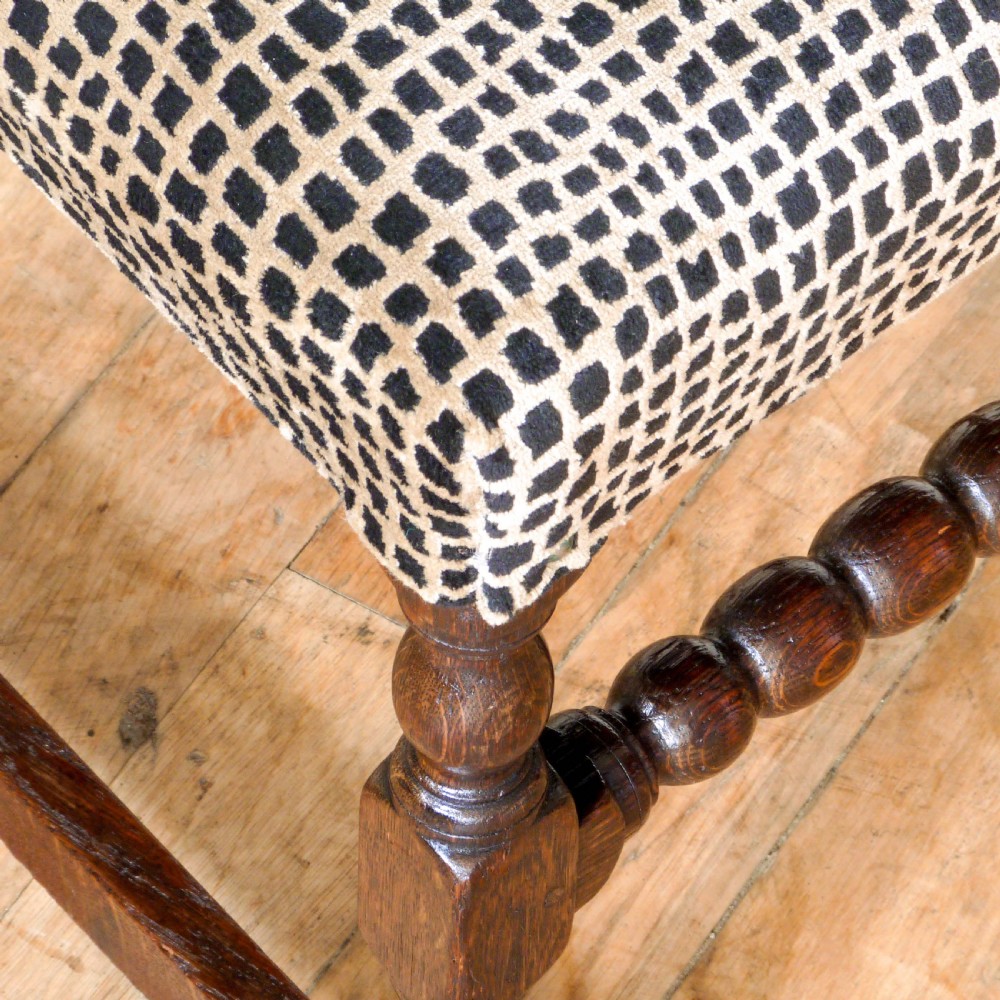 A set of six dark oak Derbyshire style dining chairs featuring intricately carved crescent backs, bobbin-turned front stretchers, and patterned upholstered seats. View XI