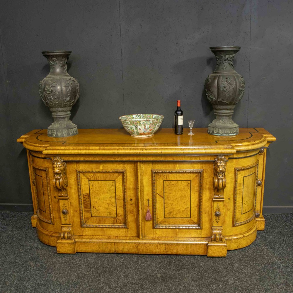 A Victorian pollard oak credenza featuring curved breakfront ends, ebonised geometric line inlay, and carved lion mask corbels. View II