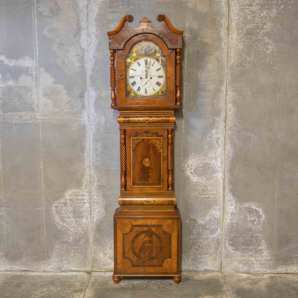A tall Georgian mahogany longcase clock featuring a swan-neck pediment, turned side columns, floral marquetry inlays, and a painted clock face with Roman numerals. View II