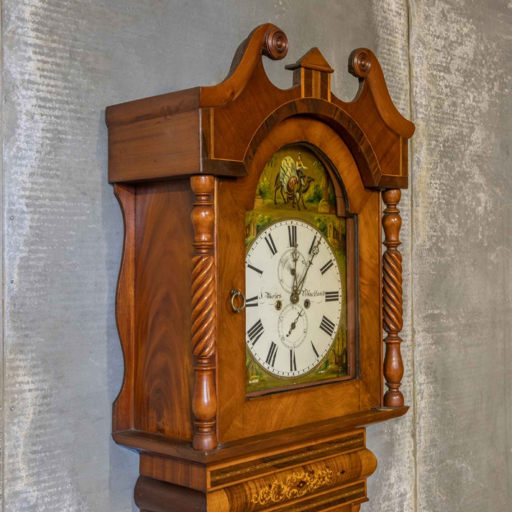 A tall Georgian mahogany longcase clock featuring a swan-neck pediment, turned side columns, floral marquetry inlays, and a painted clock face with Roman numerals. View III