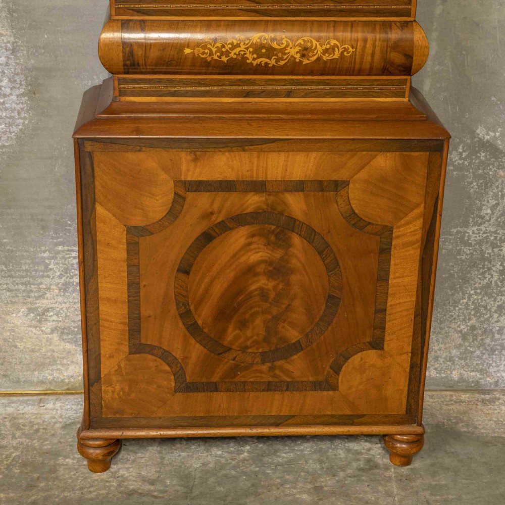 A tall Georgian mahogany longcase clock featuring a swan-neck pediment, turned side columns, floral marquetry inlays, and a painted clock face with Roman numerals. View XIII