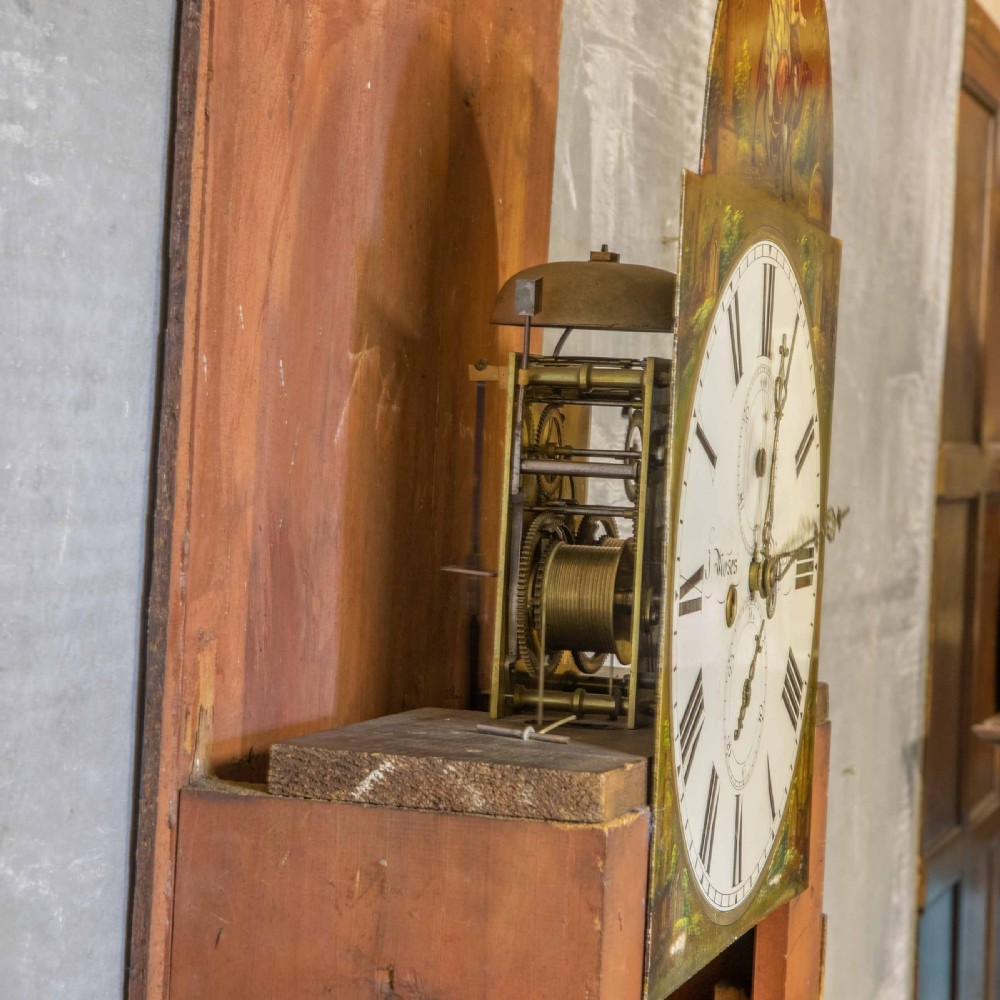 A tall Georgian mahogany longcase clock featuring a swan-neck pediment, turned side columns, floral marquetry inlays, and a painted clock face with Roman numerals. View XV