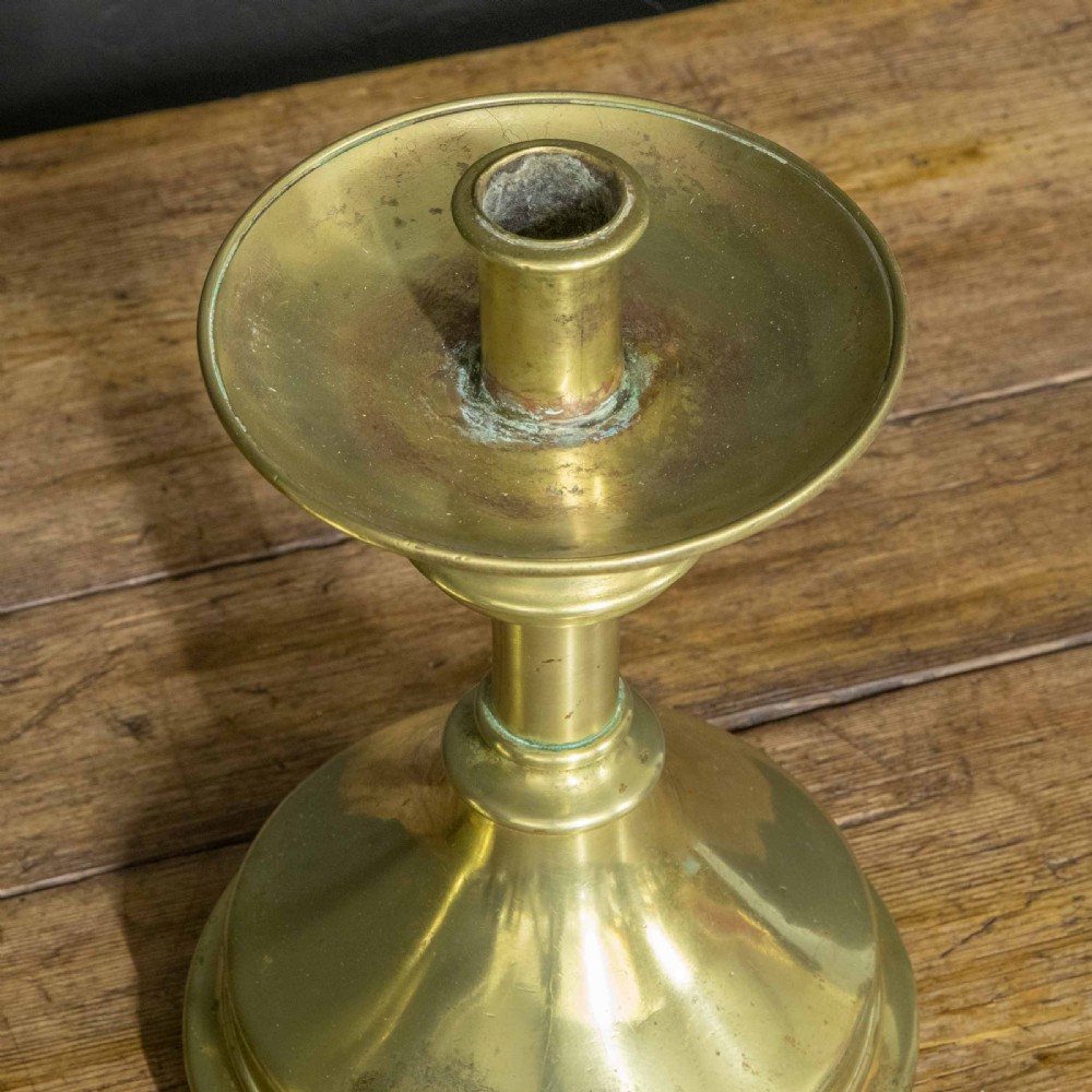 A pair of Victorian solid brass pricket candlesticks featuring wide circular drip pans, turned knopped stems, and broad bell-shaped bases. View VII
