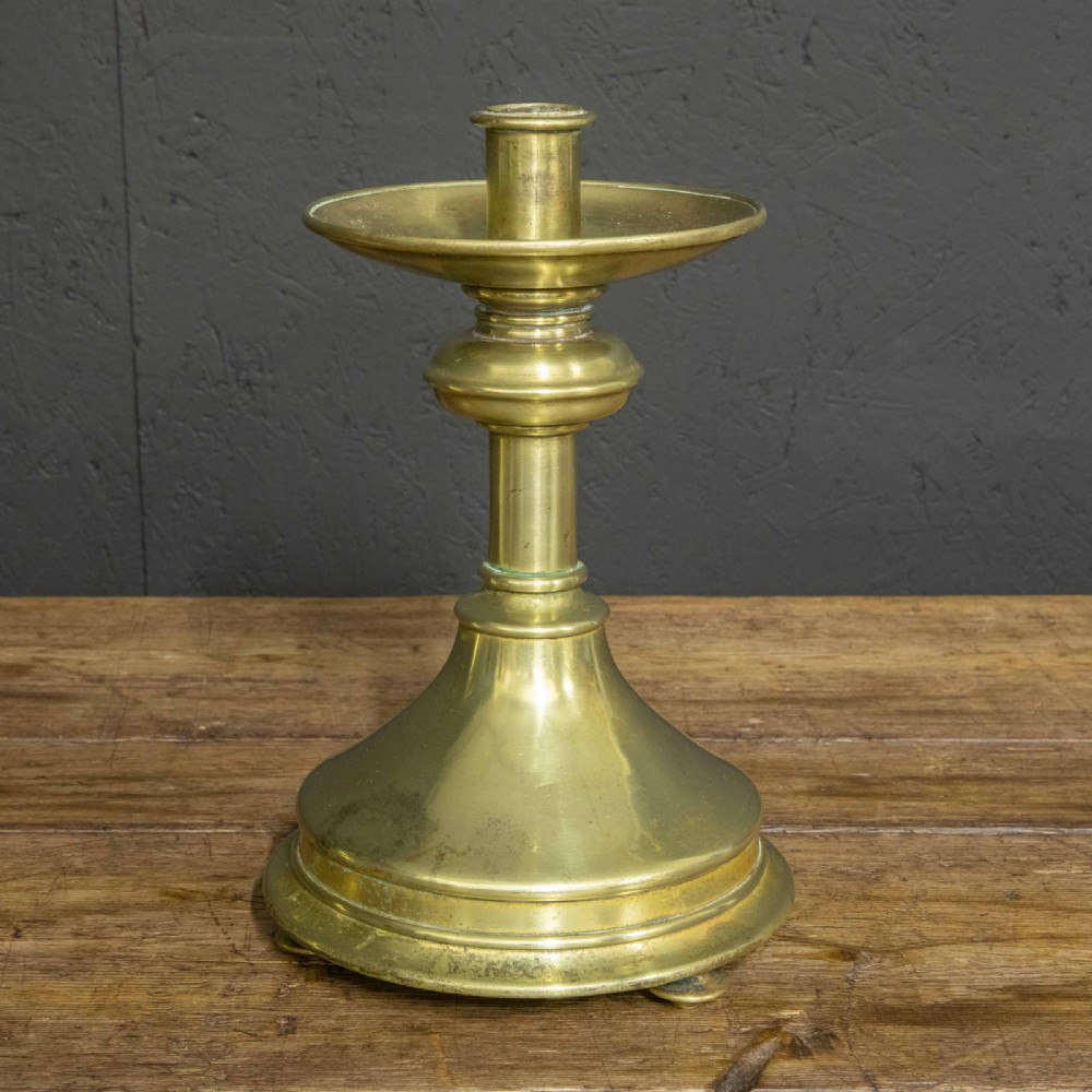 A pair of Victorian solid brass pricket candlesticks featuring wide circular drip pans, turned knopped stems, and broad bell-shaped bases. View VIII