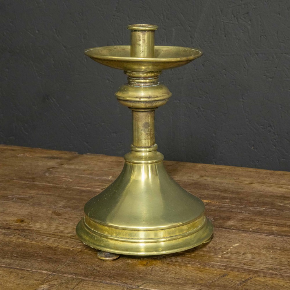 A pair of Victorian solid brass pricket candlesticks featuring wide circular drip pans, turned knopped stems, and broad bell-shaped bases. View IX