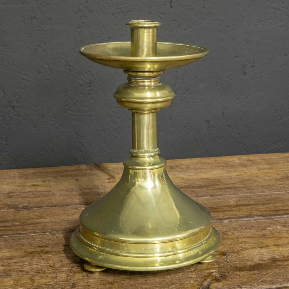 A pair of Victorian solid brass pricket candlesticks featuring wide circular drip pans, turned knopped stems, and broad bell-shaped bases. View XI