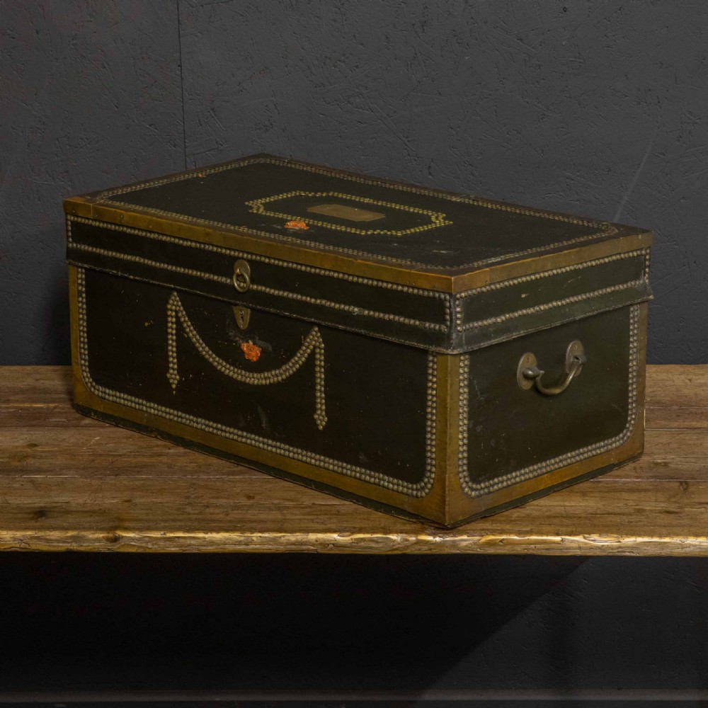 An early nineteenth-century dark green leather coaching trunk featuring brass stud embellishments in a festoon pattern and side carrying handles.