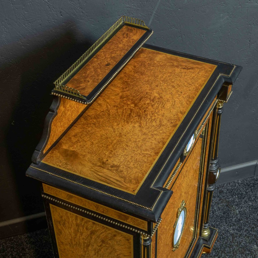 A pair of Victorian ebonised and amboyna pier cabinets featuring raised brass galleries and central blue porcelain Jasperware plaques. View II