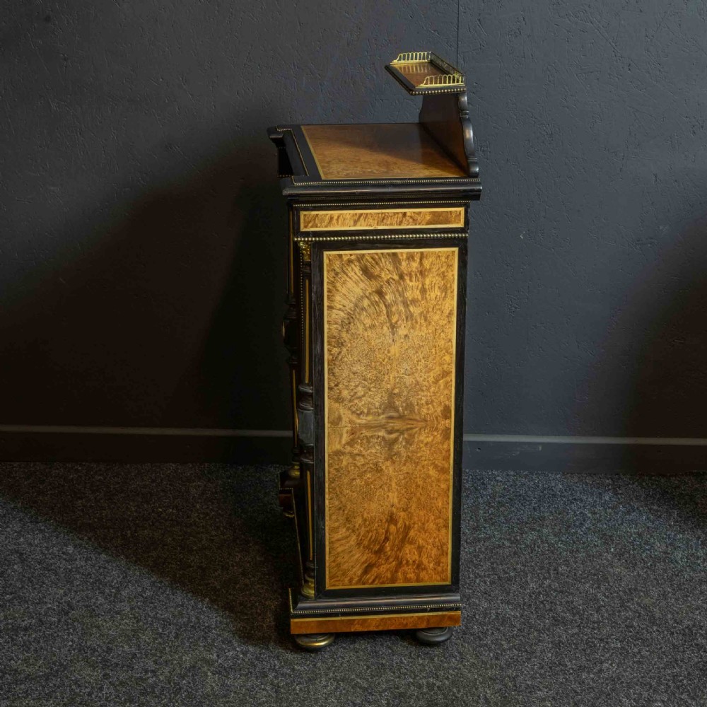 A pair of Victorian ebonised and amboyna pier cabinets featuring raised brass galleries and central blue porcelain Jasperware plaques. View V