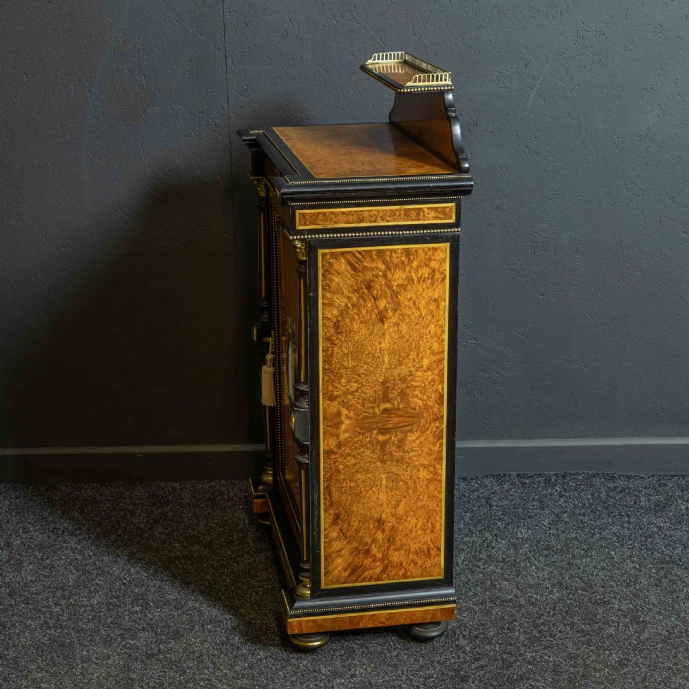 A pair of Victorian ebonised and amboyna pier cabinets featuring raised brass galleries and central blue porcelain Jasperware plaques. View XXIV