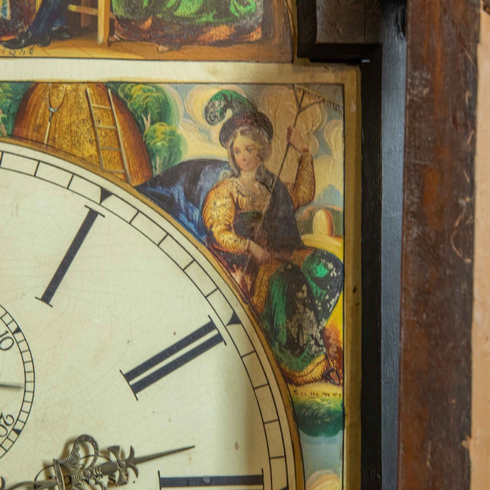 An antique Scottish mahogany longcase clock featuring a swan neck pediment, turned hood columns, flame mahogany trunk door, and a hand-painted dial. View VI
