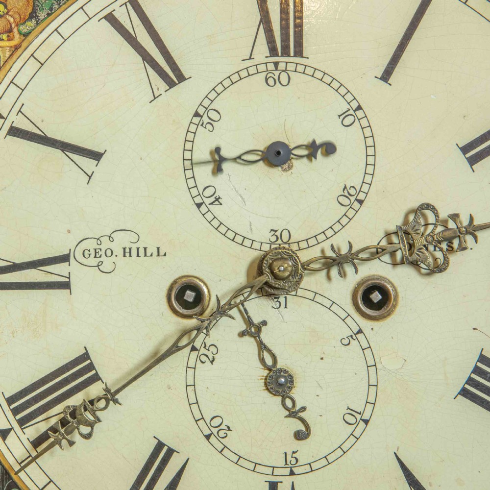An antique Scottish mahogany longcase clock featuring a swan neck pediment, turned hood columns, flame mahogany trunk door, and a hand-painted dial. View IX