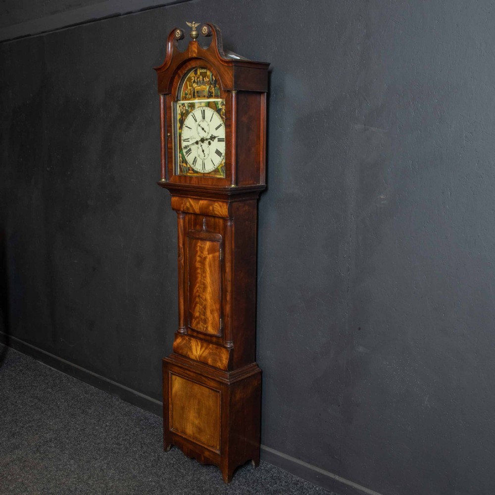 An antique Scottish mahogany longcase clock featuring a swan neck pediment, turned hood columns, flame mahogany trunk door, and a hand-painted dial. View XIII