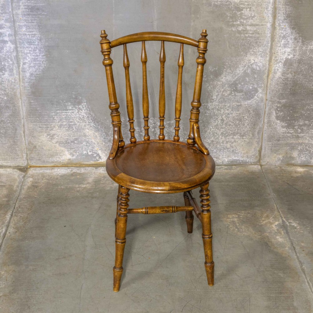 A set of four warm brown wooden bentwood dining chairs featuring spindle backrests and circular seats. View II