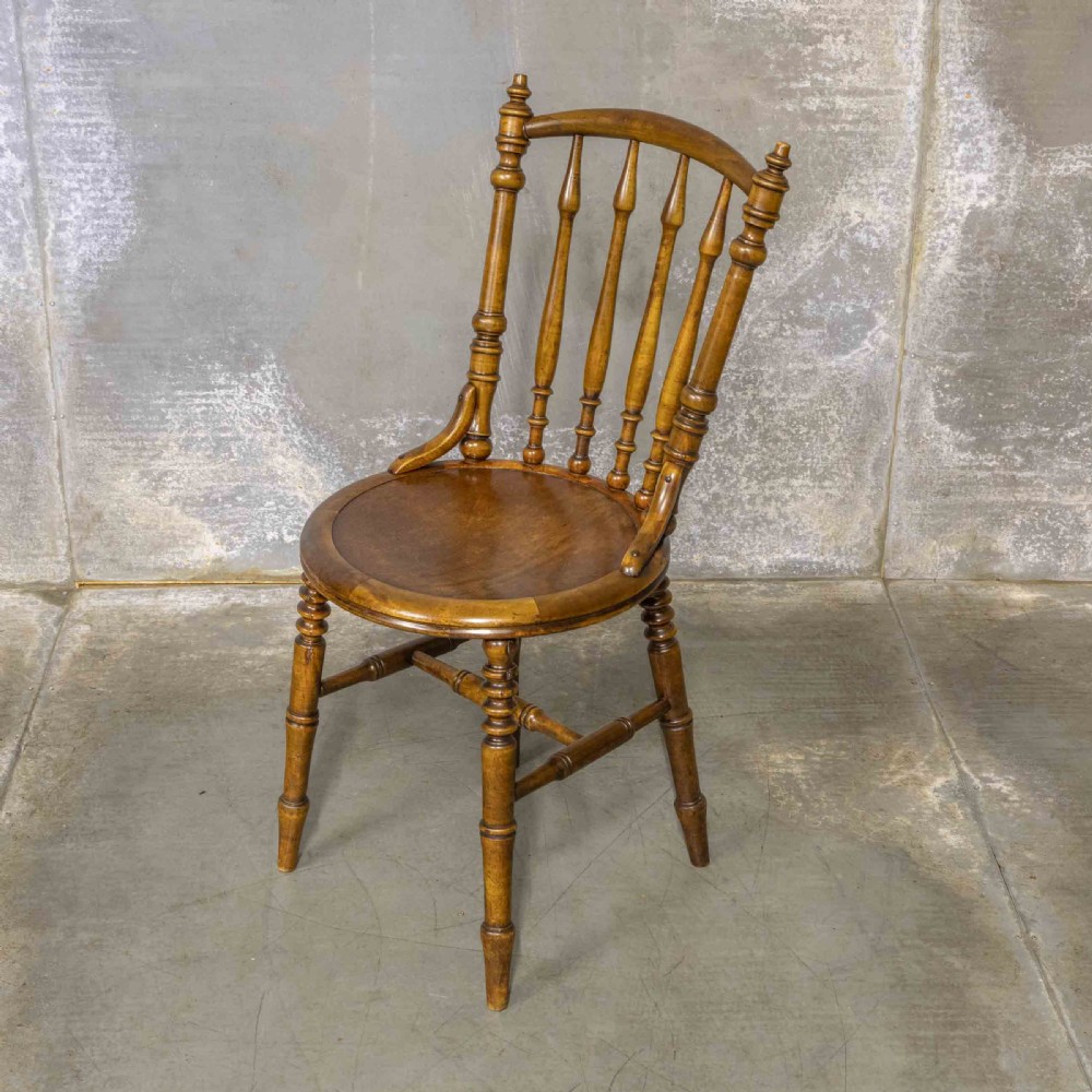 A set of four warm brown wooden bentwood dining chairs featuring spindle backrests and circular seats. View III