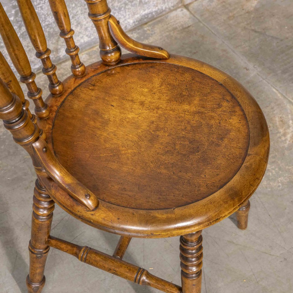 A set of four warm brown wooden bentwood dining chairs featuring spindle backrests and circular seats. View VII