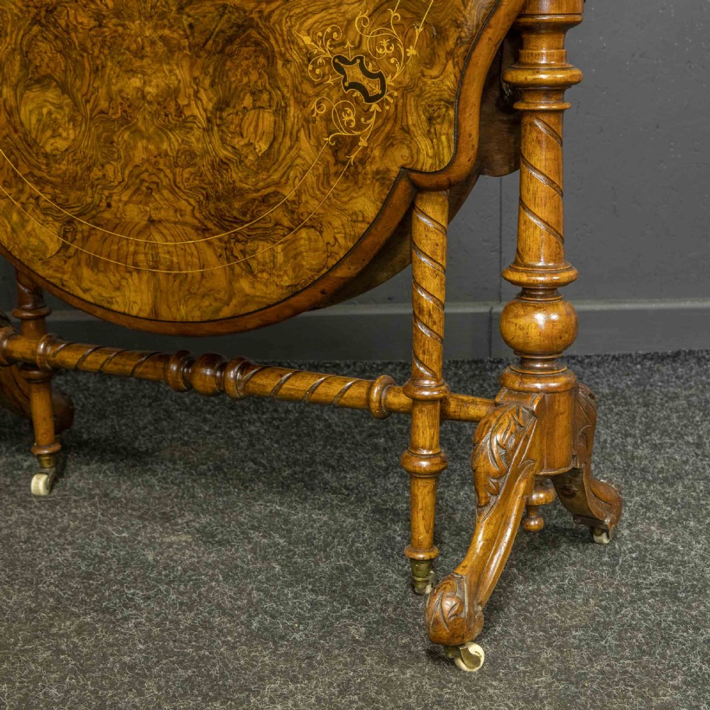 A Victorian burr walnut Sutherland drop-leaf table featuring detailed marquetry inlay, turned legs, and ceramic castors. View II