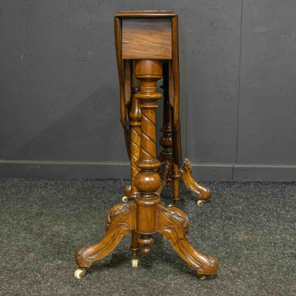 A Victorian burr walnut Sutherland drop-leaf table featuring detailed marquetry inlay, turned legs, and ceramic castors. View III