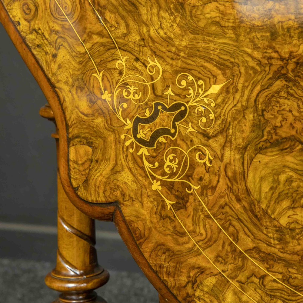 A Victorian burr walnut Sutherland drop-leaf table featuring detailed marquetry inlay, turned legs, and ceramic castors. View V