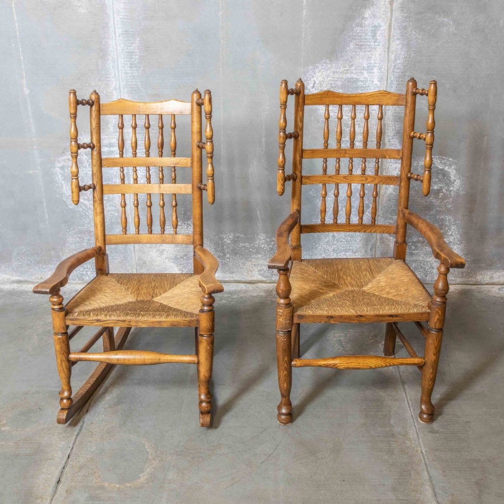 A pair of matching Victorian country armchairs in warm wood with woven rush seats and turned spindle backs, including one rocking chair and one static armchair. View II