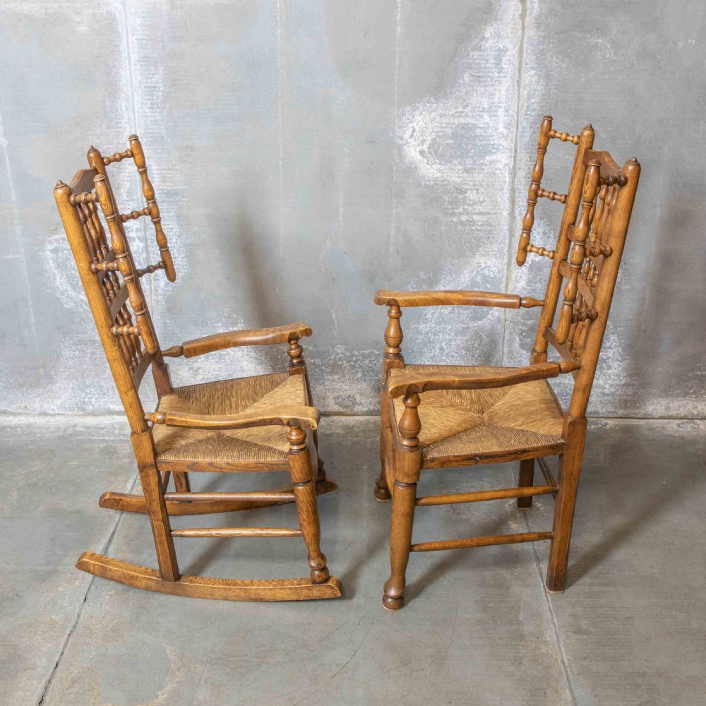 A pair of matching Victorian country armchairs in warm wood with woven rush seats and turned spindle backs, including one rocking chair and one static armchair. View III