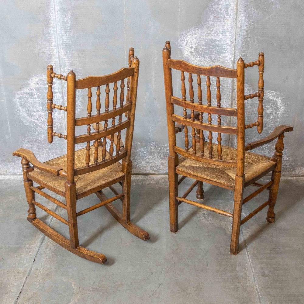A pair of matching Victorian country armchairs in warm wood with woven rush seats and turned spindle backs, including one rocking chair and one static armchair. View IV