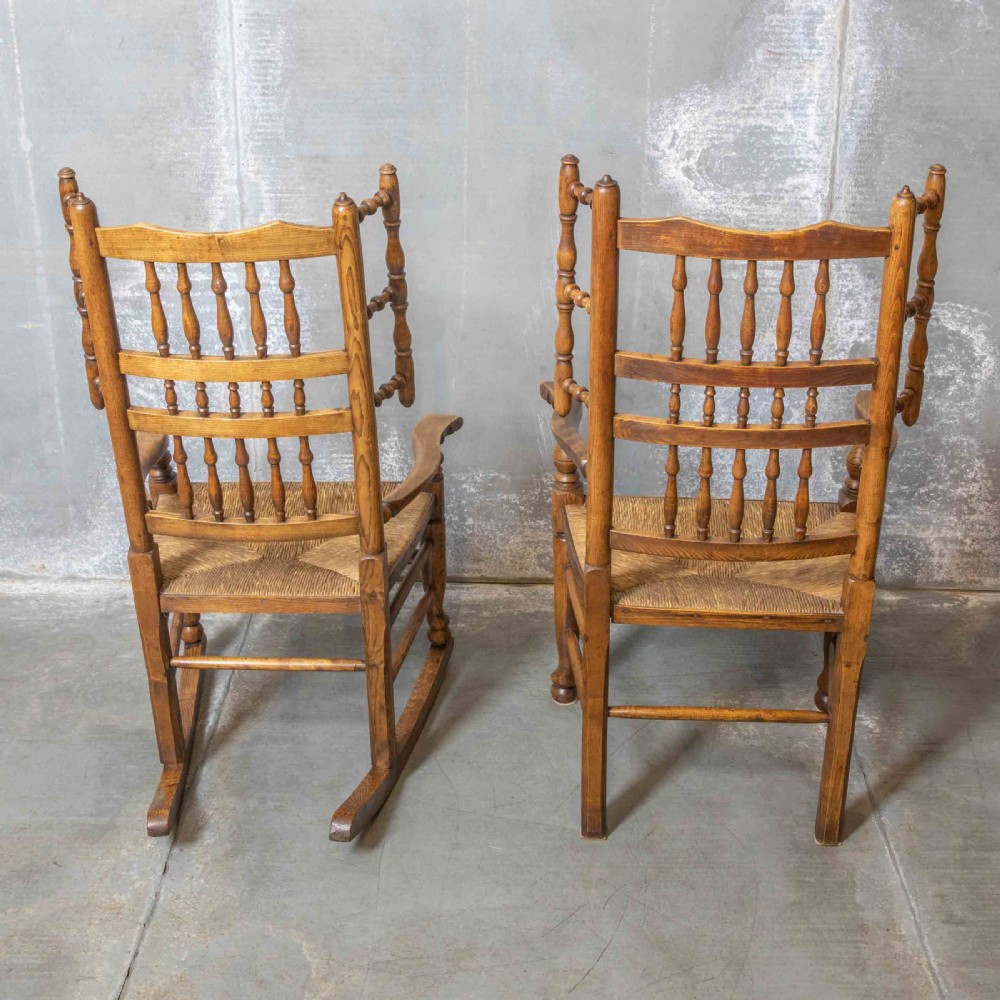 A pair of matching Victorian country armchairs in warm wood with woven rush seats and turned spindle backs, including one rocking chair and one static armchair. View XI
