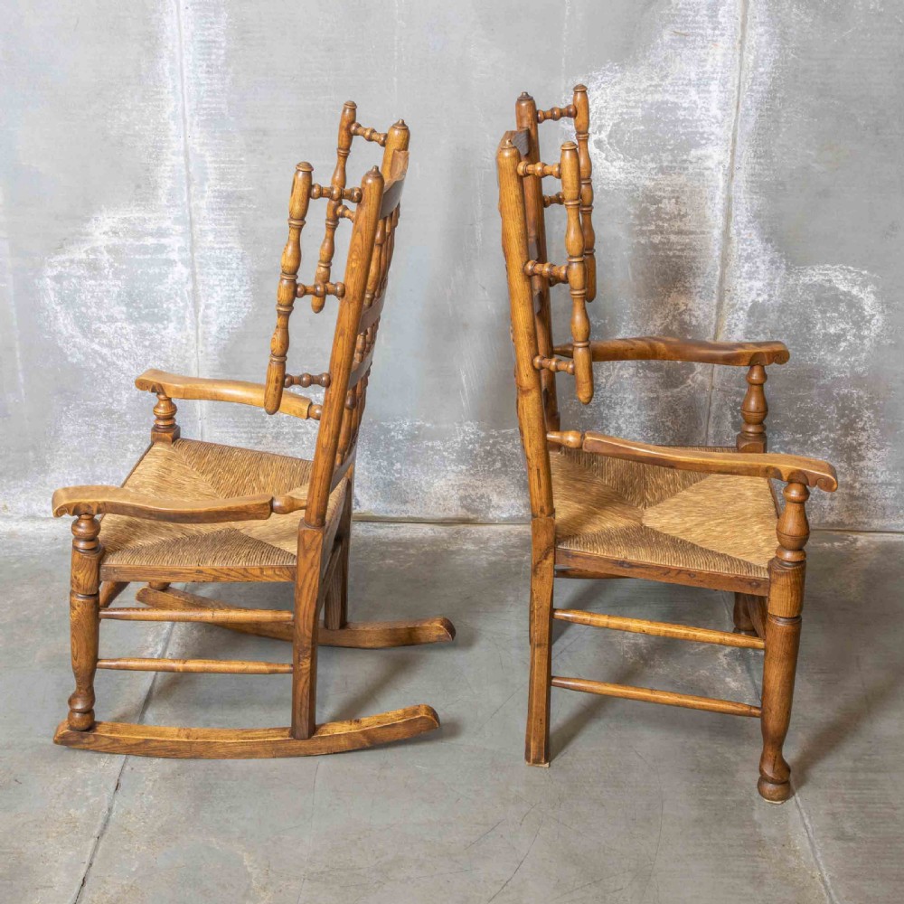 A pair of matching Victorian country armchairs in warm wood with woven rush seats and turned spindle backs, including one rocking chair and one static armchair. View XII