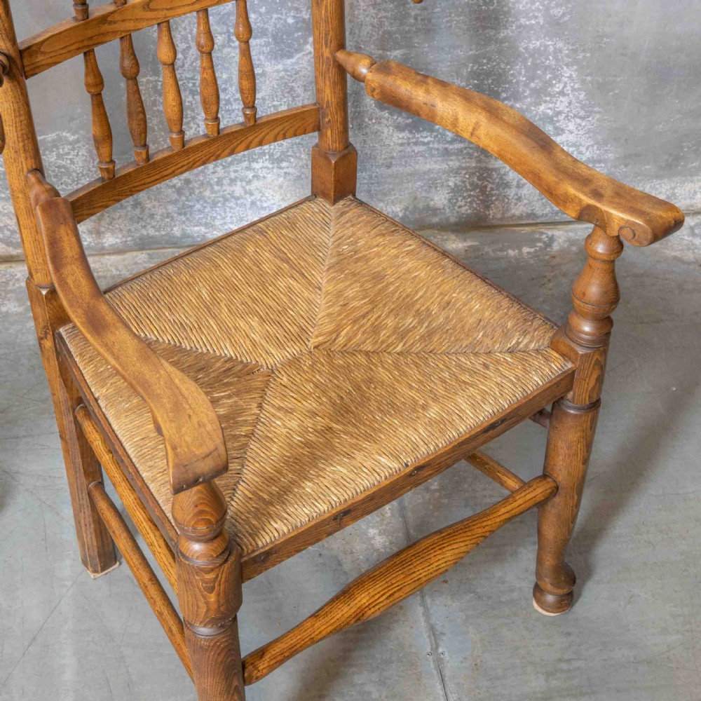 A pair of matching Victorian country armchairs in warm wood with woven rush seats and turned spindle backs, including one rocking chair and one static armchair. View XIII