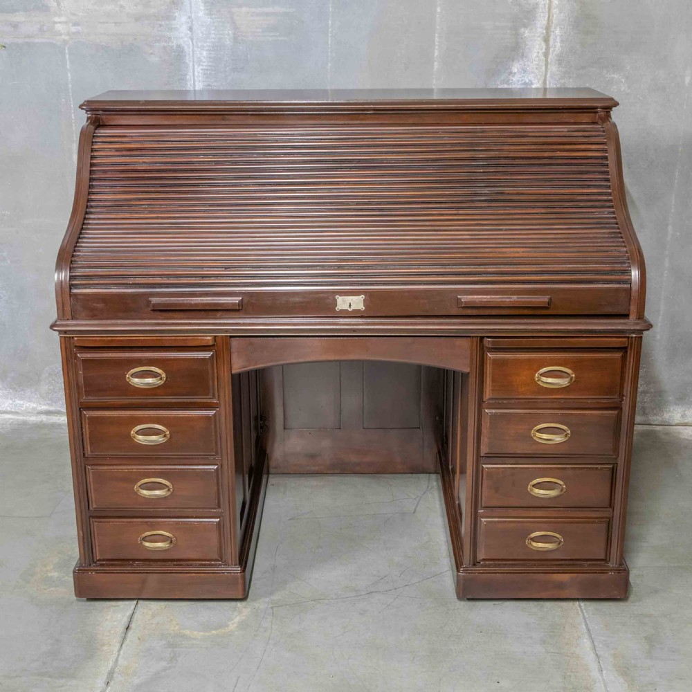 An Edwardian walnut double-pedestal roll top desk featuring a slatted tambour cover, inset green leather writing surface, multiple small interior drawers, and twin pedestal drawers with brass handles. View XIII
