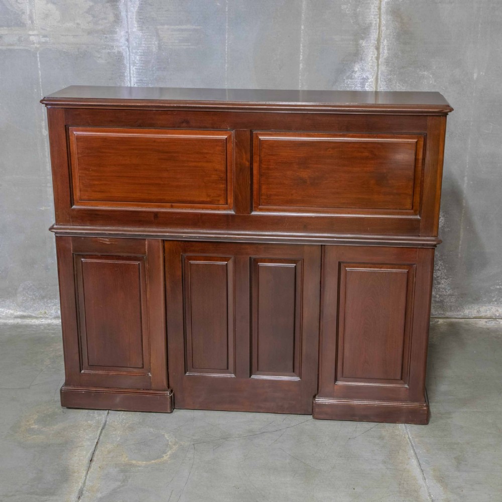 An Edwardian walnut double-pedestal roll top desk featuring a slatted tambour cover, inset green leather writing surface, multiple small interior drawers, and twin pedestal drawers with brass handles. View XVIII