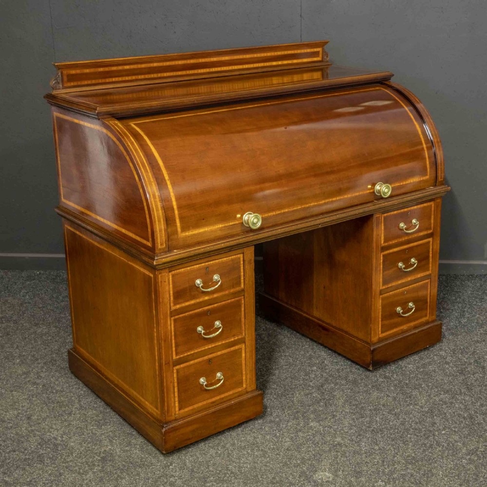 An antique mahogany cylinder desk featuring inlaid satinwood borders, a pull-out leather writing slope, fitted pigeonholes, and twin drawer pedestals. View III