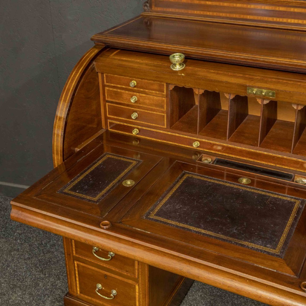 An antique mahogany cylinder desk featuring inlaid satinwood borders, a pull-out leather writing slope, fitted pigeonholes, and twin drawer pedestals. View XI