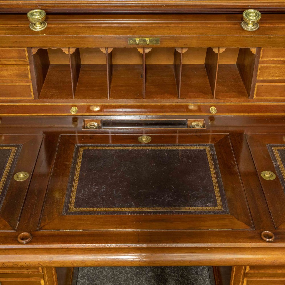 An antique mahogany cylinder desk featuring inlaid satinwood borders, a pull-out leather writing slope, fitted pigeonholes, and twin drawer pedestals. View XII