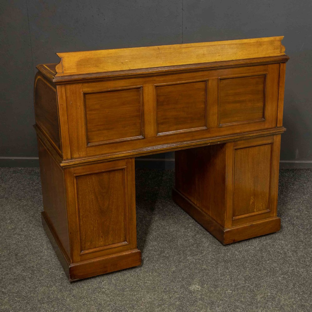 An antique mahogany cylinder desk featuring inlaid satinwood borders, a pull-out leather writing slope, fitted pigeonholes, and twin drawer pedestals. View XVI