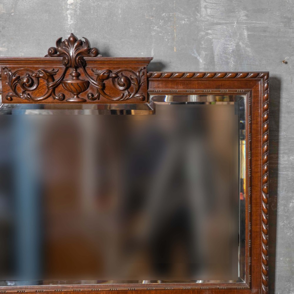 A rectangular Victorian Chippendale style mahogany wall mirror featuring a carved urn cresting, decorative scrollwork, and bevelled glass. View II