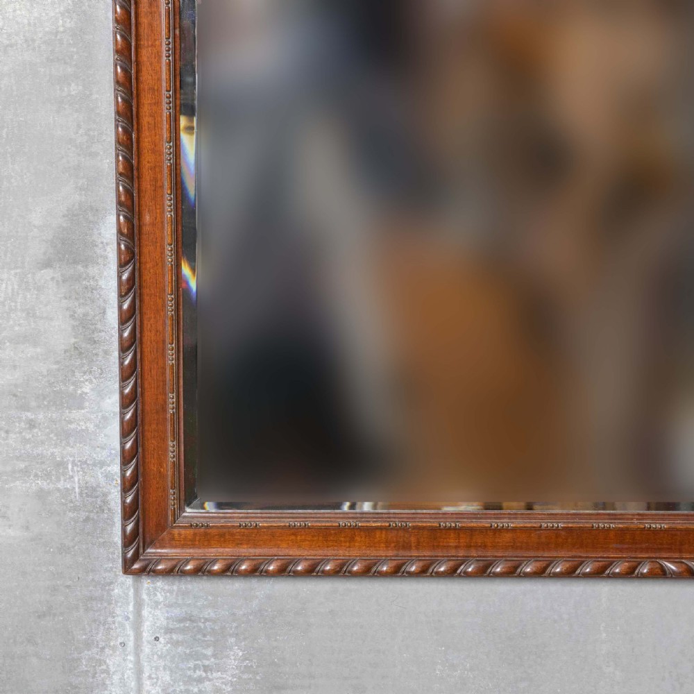 A rectangular Victorian Chippendale style mahogany wall mirror featuring a carved urn cresting, decorative scrollwork, and bevelled glass. View IV
