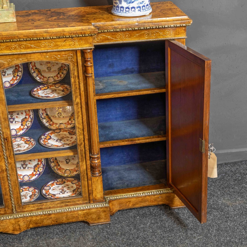 A Victorian burr walnut credenza featuring twin glazed central doors flanked by inlaid cupboard doors set with blue porcelain plaques. View III
