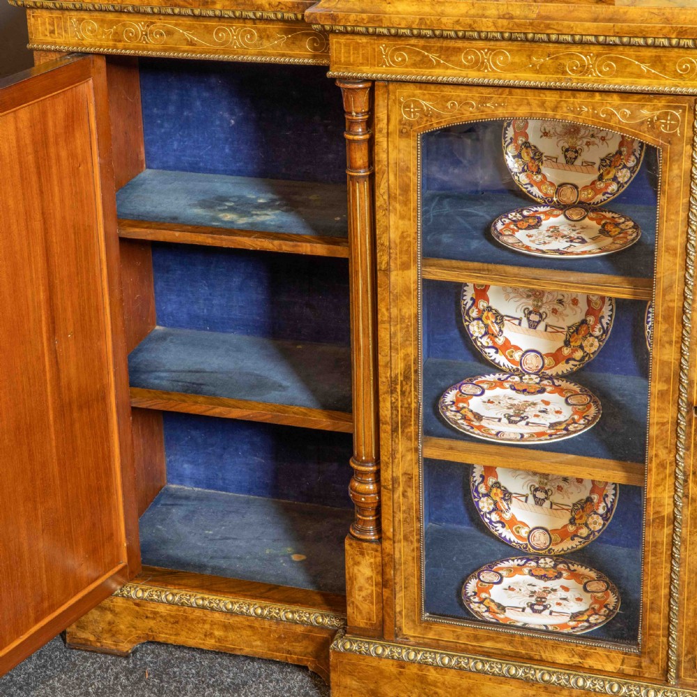 A Victorian burr walnut credenza featuring twin glazed central doors flanked by inlaid cupboard doors set with blue porcelain plaques. View V