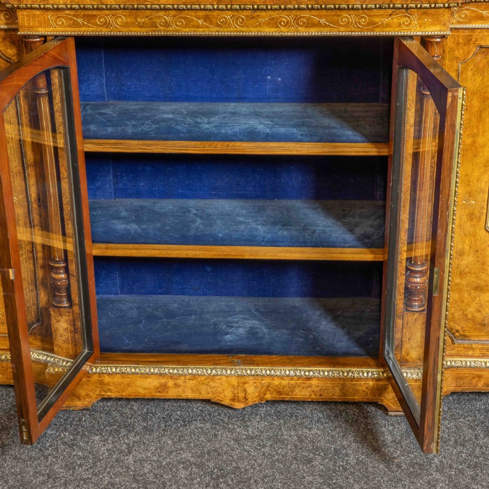 A Victorian burr walnut credenza featuring twin glazed central doors flanked by inlaid cupboard doors set with blue porcelain plaques. View VI