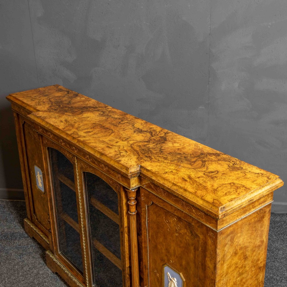 A Victorian burr walnut credenza featuring twin glazed central doors flanked by inlaid cupboard doors set with blue porcelain plaques. View VIII