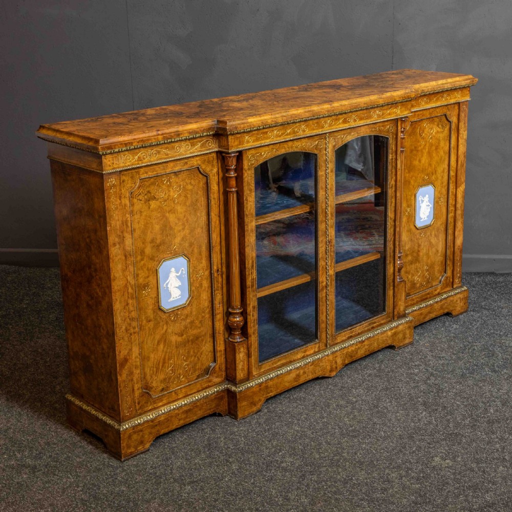 A Victorian burr walnut credenza featuring twin glazed central doors flanked by inlaid cupboard doors set with blue porcelain plaques. View XII