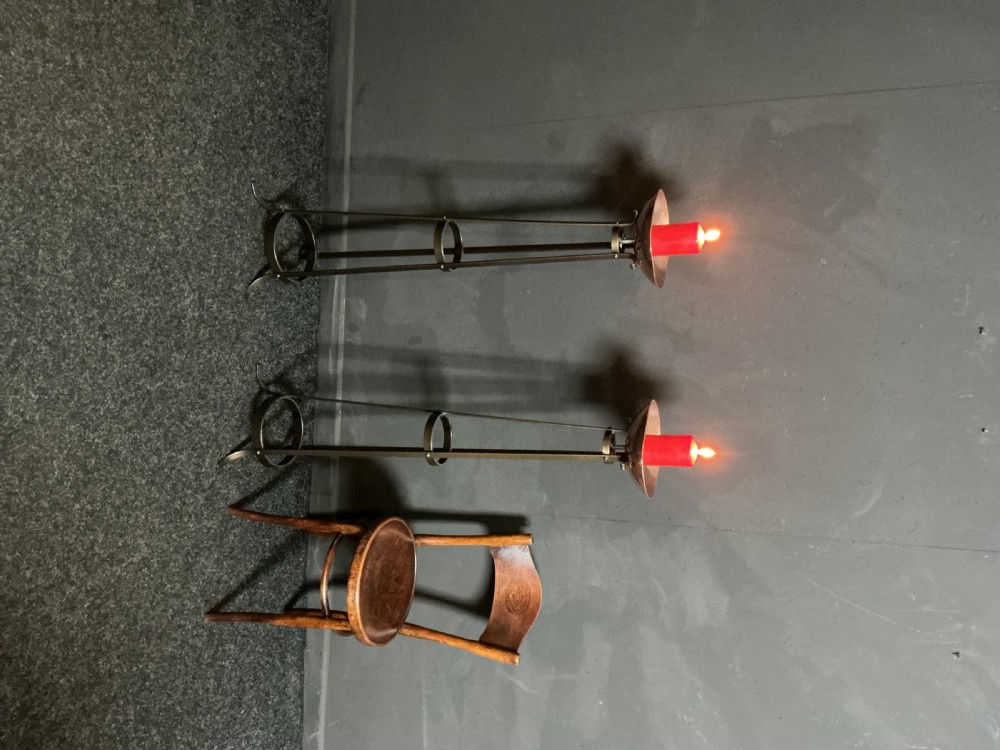 A pair of tall dark metal Art Deco floor torcheres with slender tripod frames and wide candle dish tops. View V