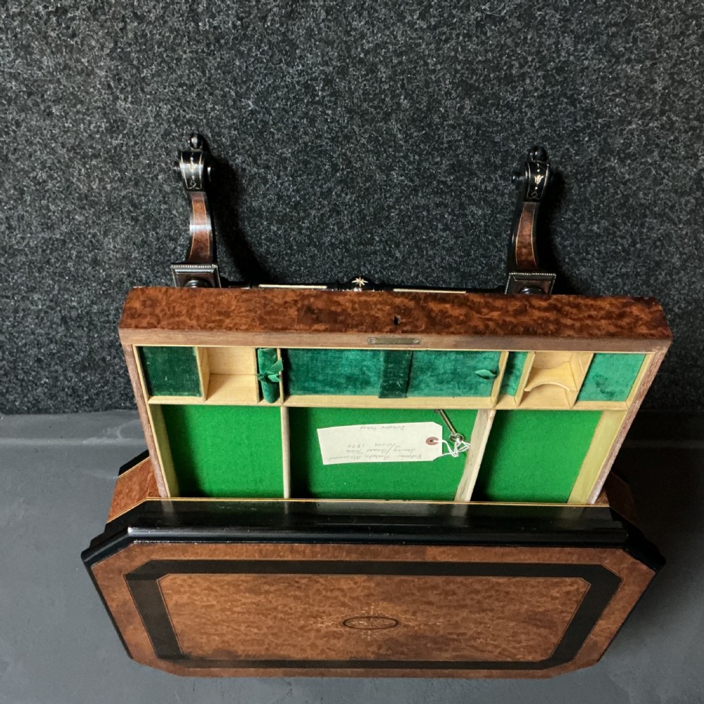 An ebonised Victorian games and sewing table featuring a fold-out top inlaid with chess and backgammon boards supported on turned twin columns. View III