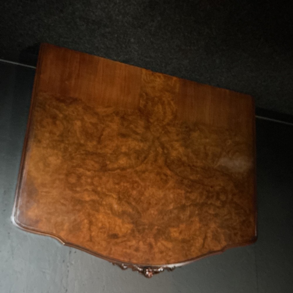 A king-size burr walnut headboard featuring an arched top rail with a central carved crest motif and prominent book-matched wood grain. View III
