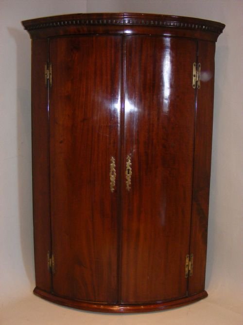 A George III Mahogany Bow-fronted Corner Cupboard.