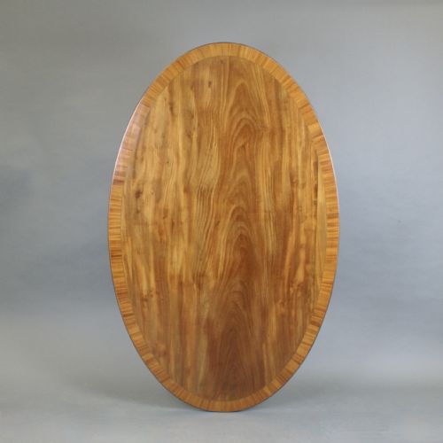 A LARGE OVAL FLAME MAHOGANY COFFEE TABLE - ADDITIONAL PHOTO 1
